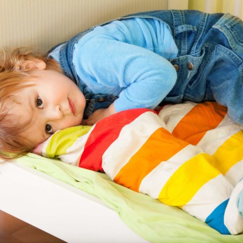 Tired Toddler Laying In His Bed