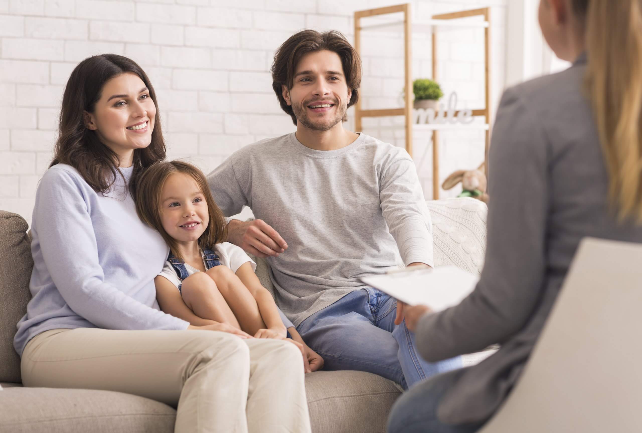 Happy Parents With Little Daughter Sitting Together At Psycholig